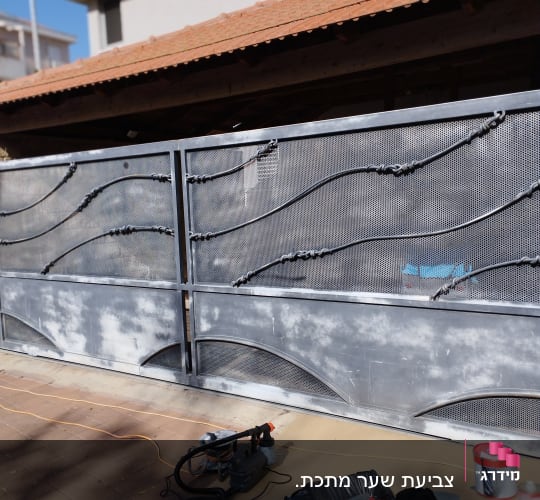 שער מתכת עם ציוד צביעה, כולל מברשת ופח צבע